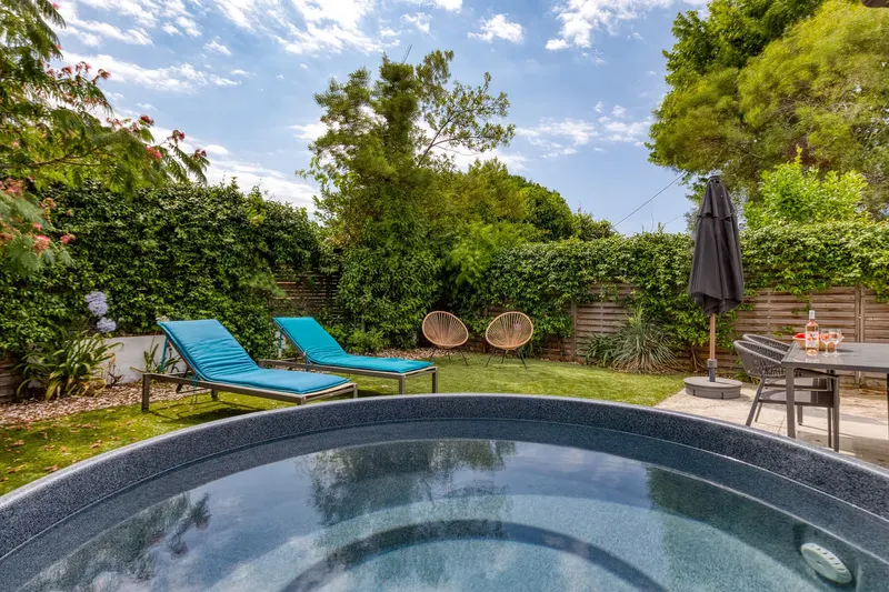 Terrasse des Ferienhauses mit einer Flasche vom Weingut